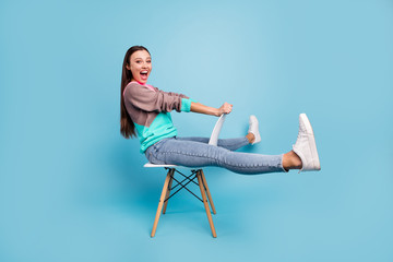 Full length photo of amazed rejoicing glad positive nice creative teen girl imaging she ridding a horse or bicycle isolated bright background