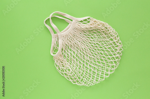 Reusable shopping bag on green background. Ecological concept. Top view of mesh shopping cotton bag. Caring for the environment and the rejection of plastic. 