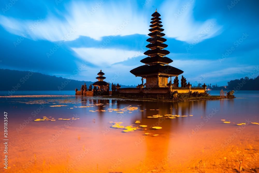 Obraz premium Ancient Ulun Danu Beratan Temple or Pura Bratan, Indonesian Hindu water temple on on the shores of Lake Bratan in the mountains near Bedugul, Bali at sunset.