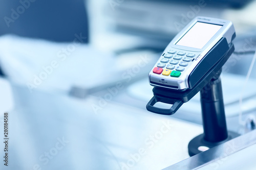 Credit card POS terminal at the checkout in a store. Retail business equipment and finance concept. Toned