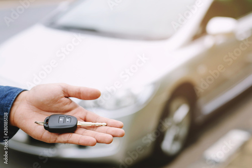 Car key, businessman handing over gives the car key to the other man on car background. Leave space for writing messages.