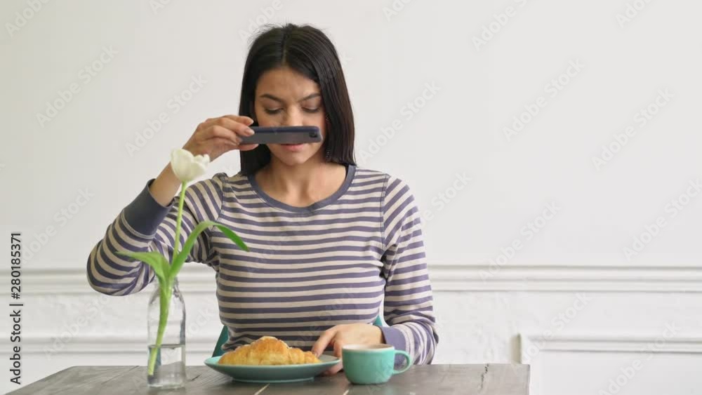 Beautiful young woman taking a picture of her breakfast on smartphone Beautiful young woman taking a picture of her breakfast on smartphone