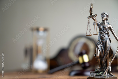 Law concept. Themis statue and judges' gavel on the rustic wooden table. 