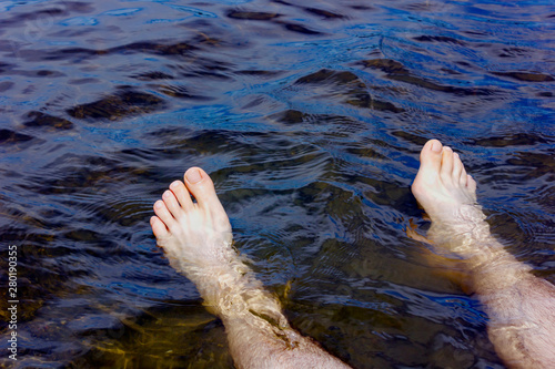 man's legs in the blue water