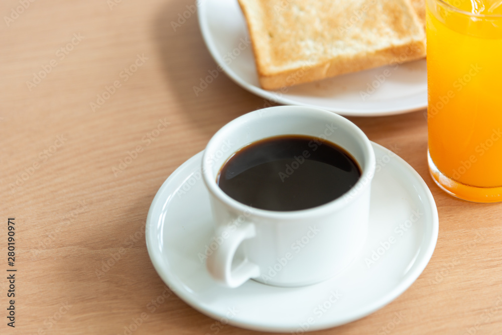 White coffee cup and toast on the table with green nature background White coffee cup and toast on the table with green nature background