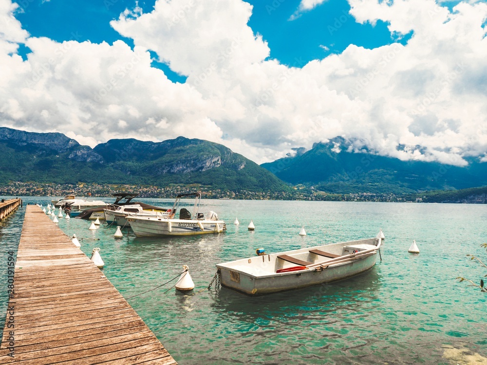 Beautiful view of the lake in Annecy in France, clear azure water, yachts and Alps