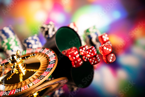 Casino concept. High contrast image of casino roulette, poker chips, dice. Bokeh background. 