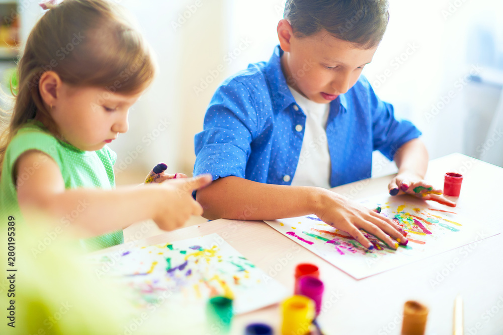 funny kids show their palms the painted paint. creative classes fine arts. two children a boy and a girl laugh. selective focusing on the palm. funny kids show their palms the painted paint. creative classes fine arts. two children a boy and a girl laugh. selective focusing on the palm.