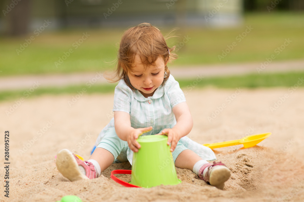 childhood, leisure and people concept - little baby girl plays with toys in sandbox childhood, leisure and people concept - little baby girl plays with toys in sandbox