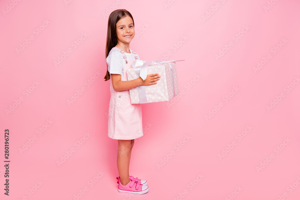 Full length photo of little funny lady hands hold large giftbox christmas holidays weekend wear sun dress isolated pink background Full length photo of little funny lady hands hold large giftbox christmas holidays weekend wear sun dress isolated pink background