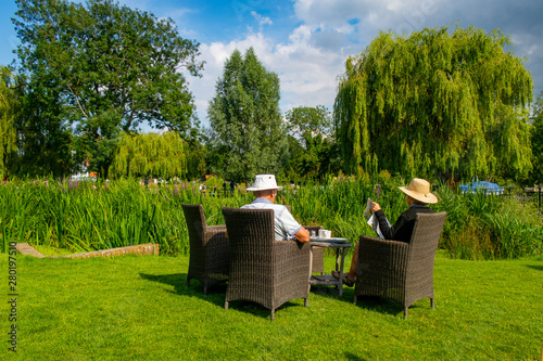 Backside of old couple having tea in the garden photo