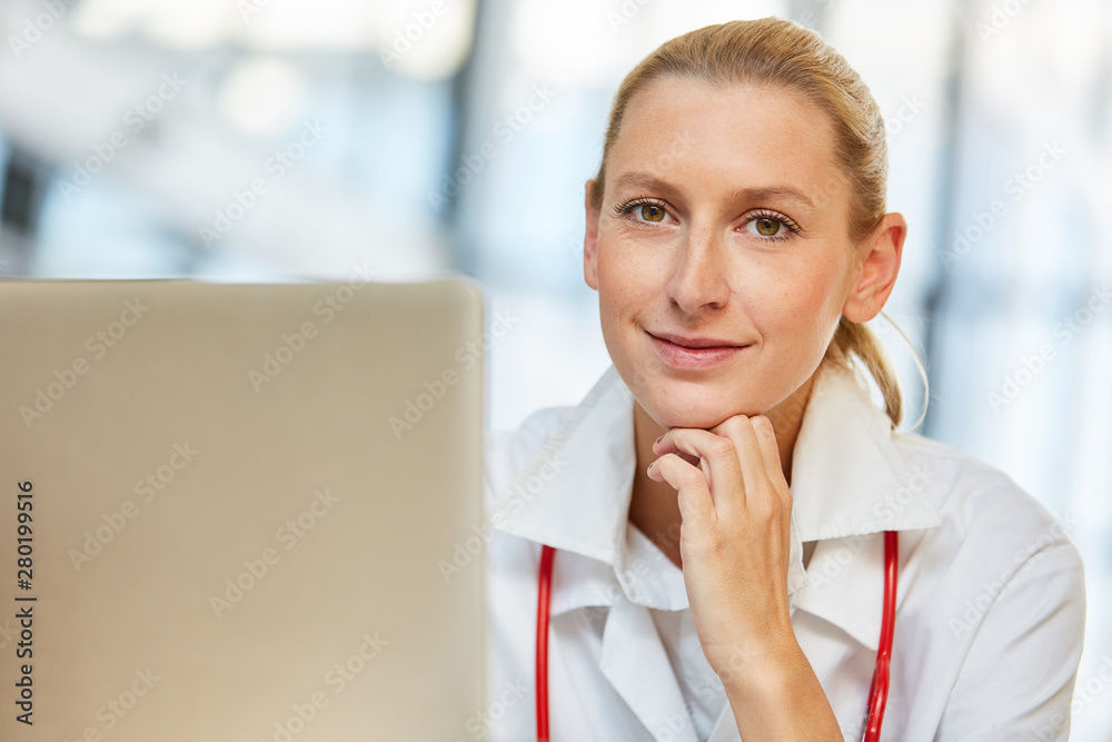 Junge Frau als freundliche Ärztin am Laptop Junge Frau als freundliche Ärztin am Laptop