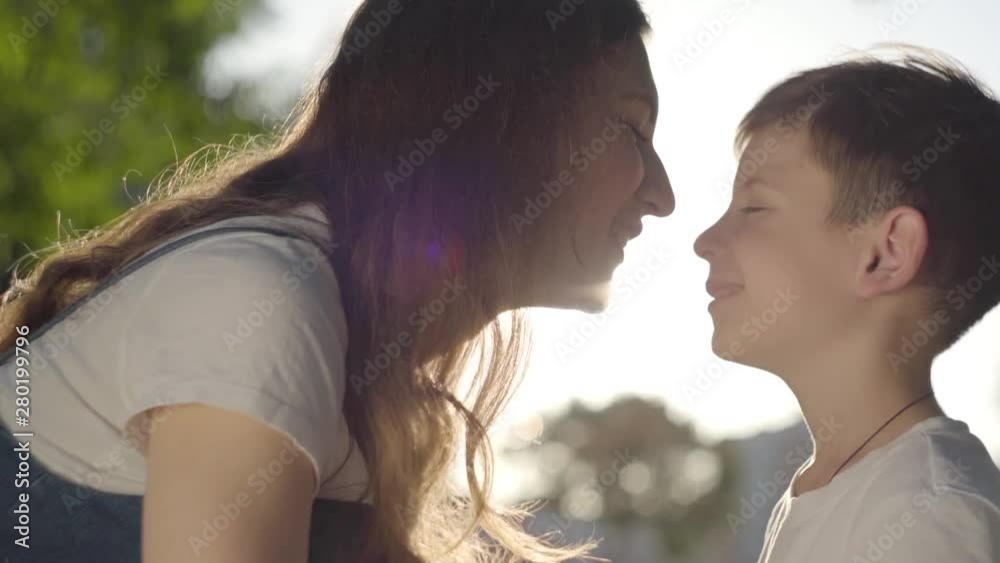 Portrait of older sister spending time with younger brother outdoors