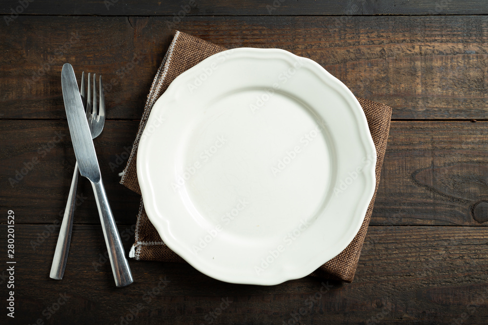 Empty white plate on wooden table. Empty white plate on wooden table.