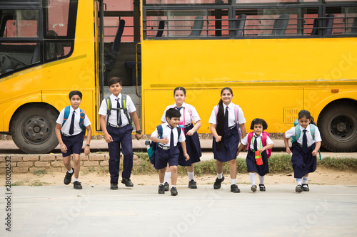 Schoolboys and schoolgirls walking of the school bus
