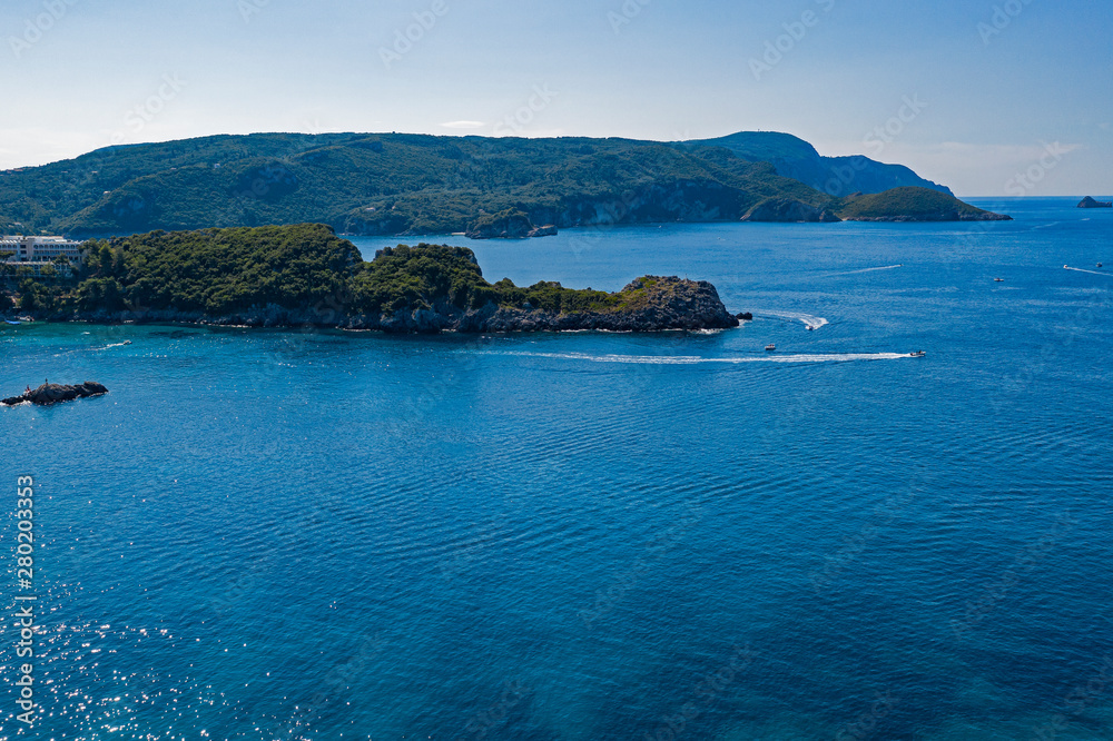 Aerial view of beautiful green and rocky island in the blue ocean. Aerial view of beautiful green and rocky island in the blue ocean.