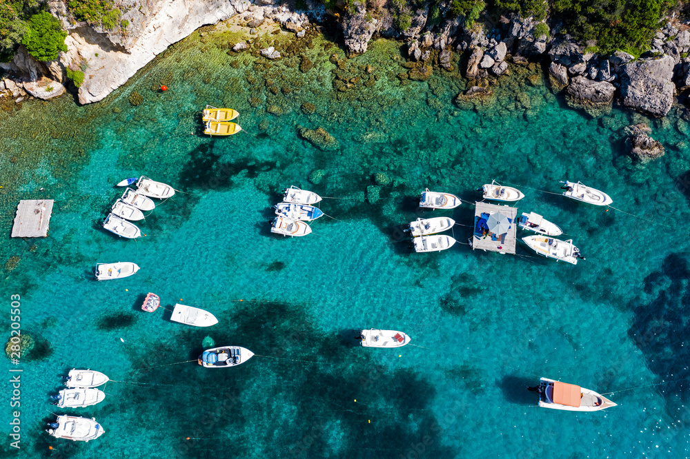 Aerial view of coastline and boats in the sea. Turquoise ocean seen from above.