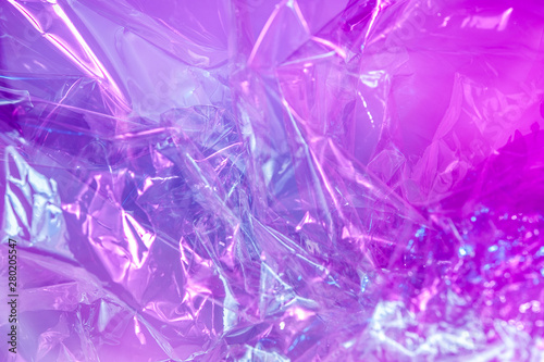 Holographic background in the style of the 80-90s. Real texture of cellophane film in bright acid colors.