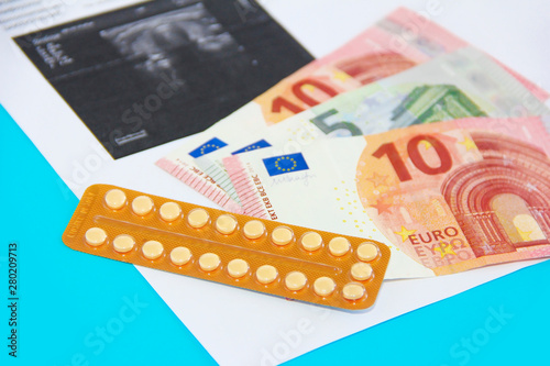 hormonal pills and euro money on the background of the sheet with ultrasound