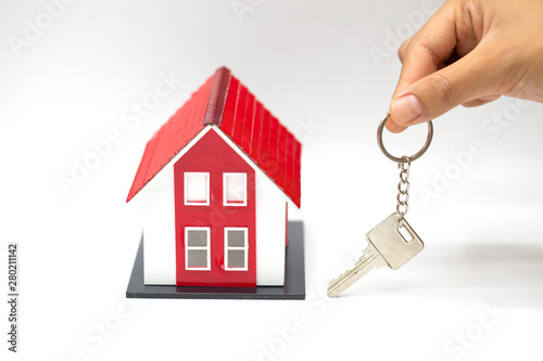 Red roof house Holding key and houses by businessmen.House in the hands of businessmen Or sales representative.Agents are giving home and home keys to customers.Home buying and home insurance concept.