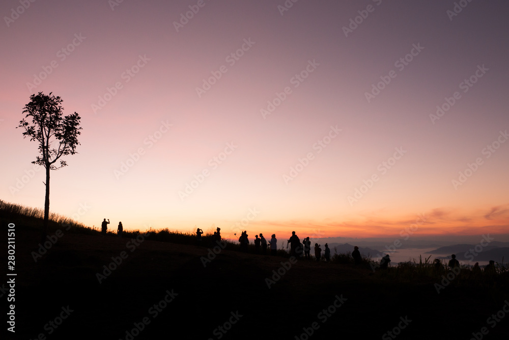 silhouette of people the cliff and looking at the valley and mountains with sunrise in the morning silhouette of people the cliff and looking at the valley and mountains with sunrise in the morning