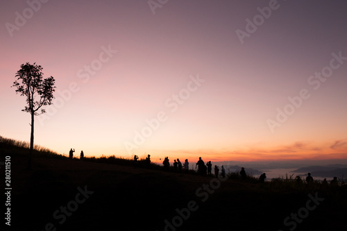 silhouette of people the cliff and looking at the valley and mountains with sunrise in the morning