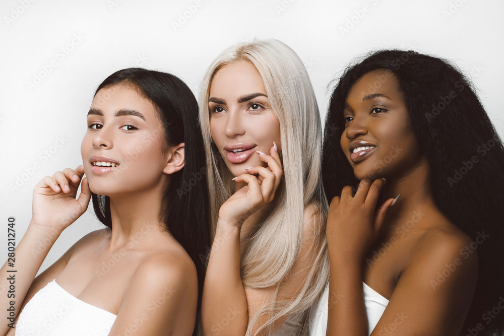 Three different nation girls with diversuty in skin, hair. Caucasian, African american and Asian girls cheerful emotional posing on white background, lifestyle people concept. Three different nation girls with diversuty in skin, hair. Caucasian, African american and Asian girls cheerful emotional posing on white background, lifestyle people concept.