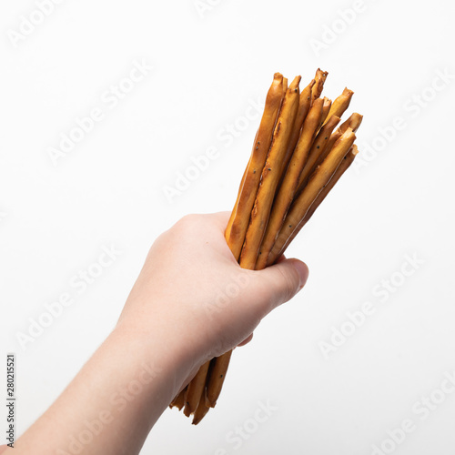 baby hand holding crispy breadsticks isolated on white background
