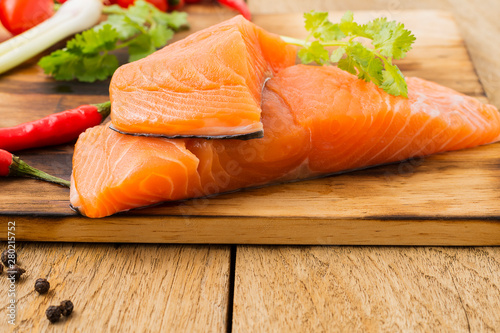 Raw salmon fillets and ingredients for cooking on old wooden floors