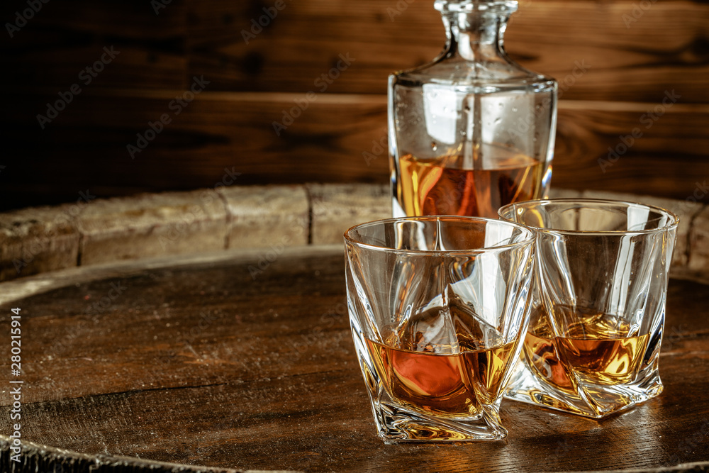 Two glasses of brandy or cognac and bottle on the wooden table Two glasses of brandy or cognac and bottle on the wooden table