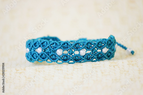 turquoise bracelete with white beads for the hand from waxed thread in the technique of macrame. Handmade.