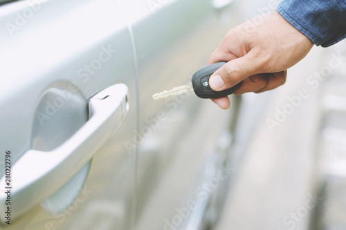 Car key in business man hand. hand presses on the remote control car alarm systems. lock or unlock the door. Leave space for writing text.