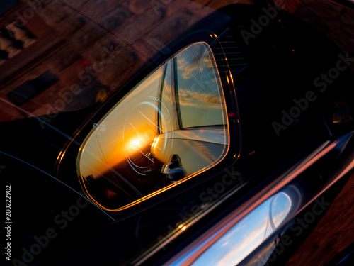 Luxury car mirror with sunset reflection