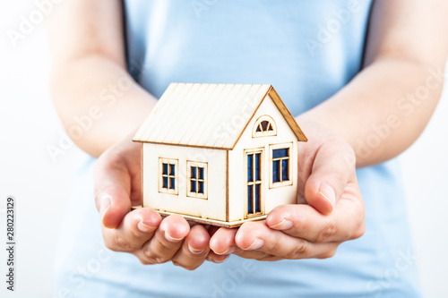 Female hands holding up a small house cabin