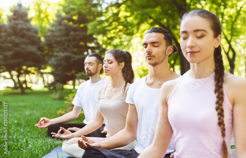Group of friends meditating in the park