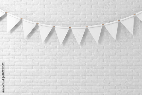 Fototapeta Naklejka Na Ścianę i Meble -  White Empty Party Flags Mock Up Hanging on White Brick Wall Background. 3d Rendering
