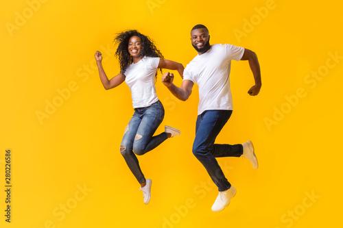 Playful black couple is running in the air