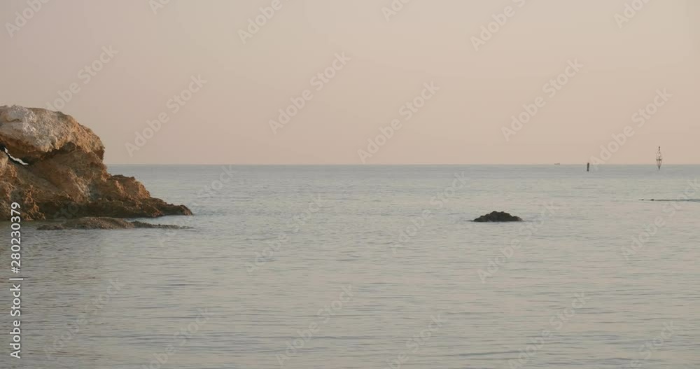 Swimmer trains in the open sea at sunrise Swimmer trains in the open sea at sunrise