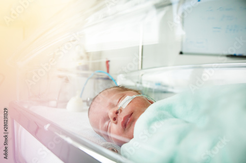 Little premature born child through hospital crib