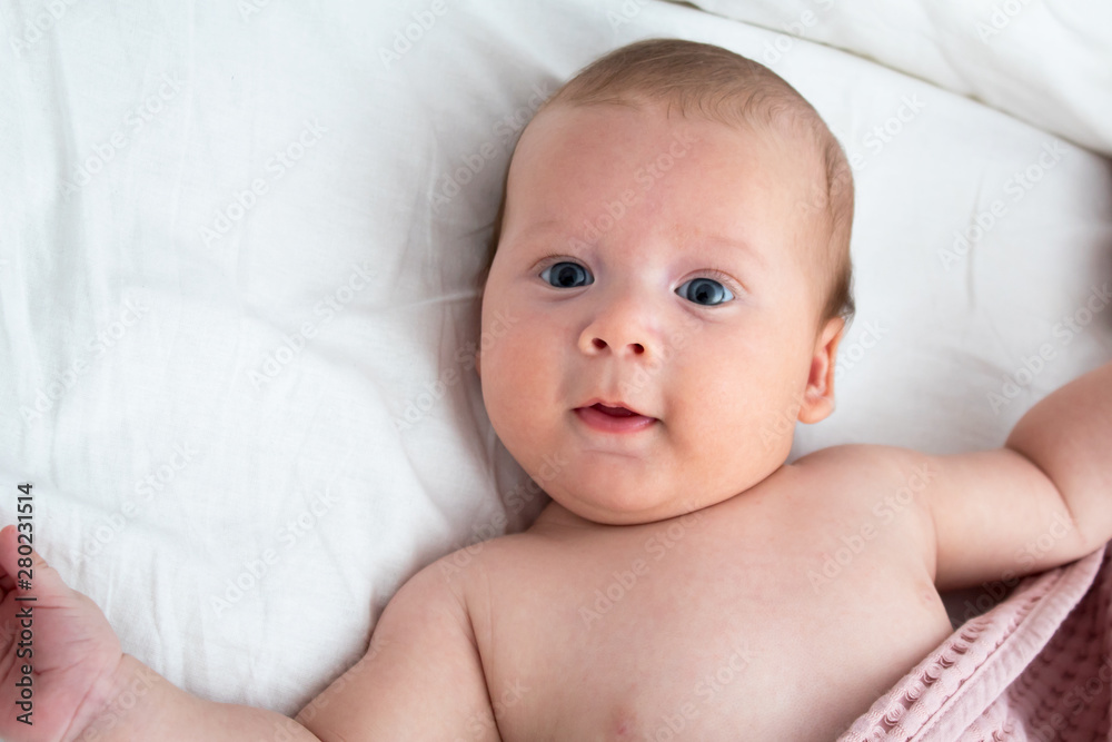 The baby smiles. Newborn lying on a white background .Top view The baby smiles. Newborn lying on a white background .Top view