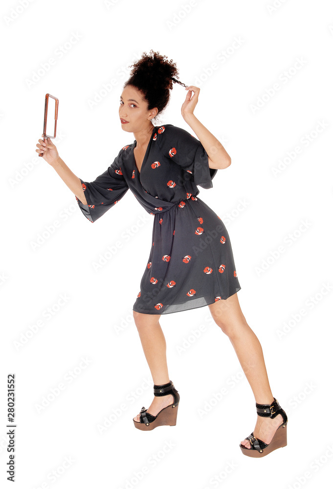 Beautiful woman in a black dress fixing her hair Beautiful woman in a black dress fixing her hair