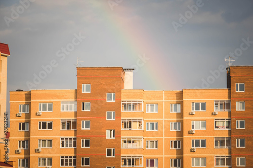 Bottow view of facade of new multi-storey residential building with bakconies made of biege brick.