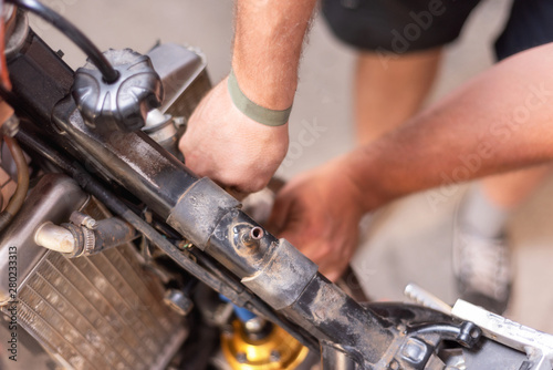 Motorbike mechanic, replacing the cooling radiator. Replacement or radiator maintenance .