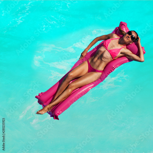 Woman sunbathing on inflatable matrass swim in sea