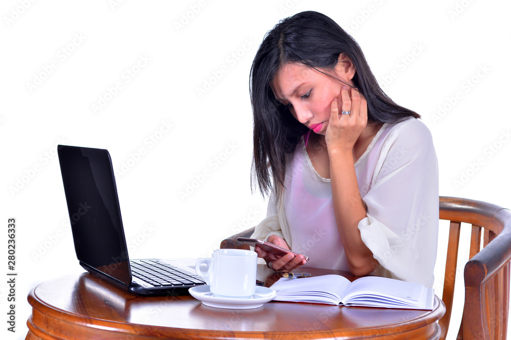 Woman using smart phone at her desk Woman using smart phone at her desk