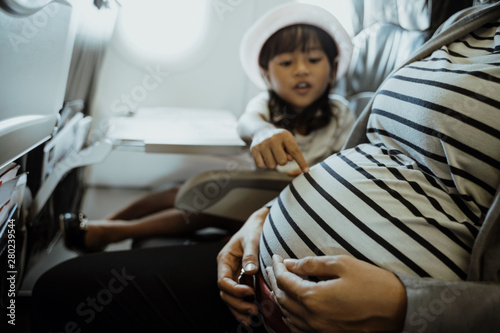 asian little girl enjoy chatting with her mother in the aircraft cabin when go on vacation