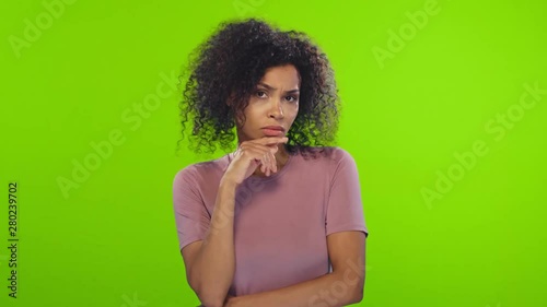 Puzzled hesitant African American female with curly hairstyle, shrugs shoulders as doesn't know the answer or can`t make a decision, how to change future life. Life perception and attitude concept.