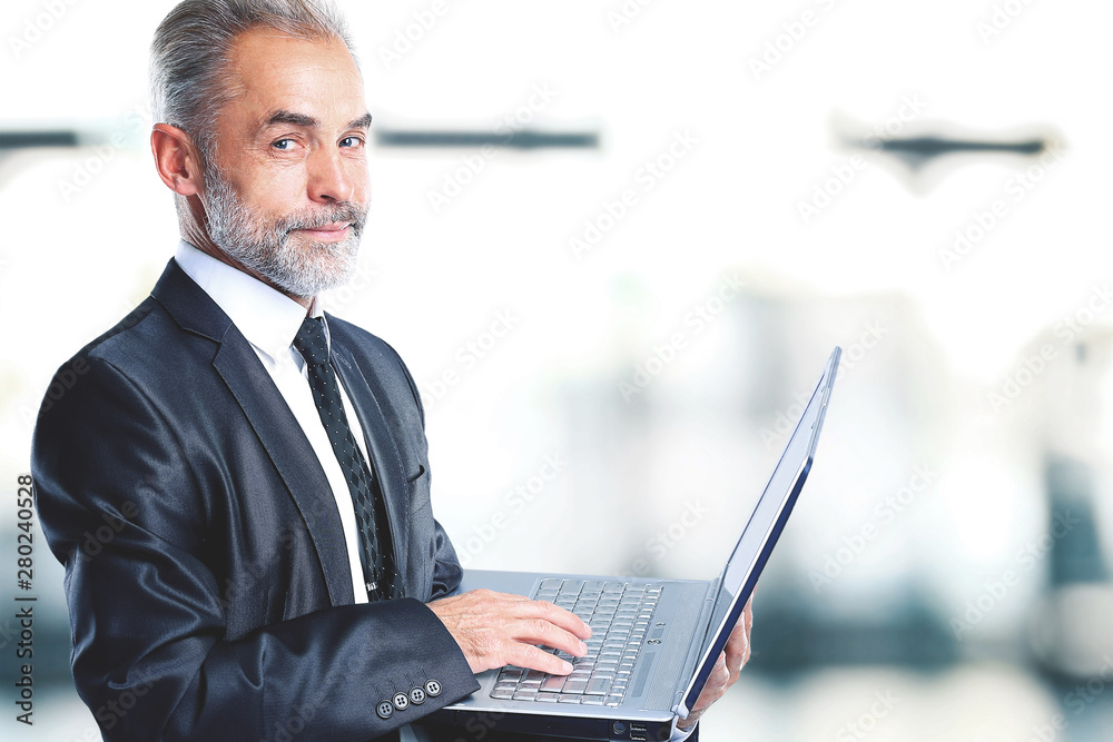 Nice businessman at the age keeps the laptop. Isolated on a white background. Nice businessman at the age keeps the laptop. Isolated on a white background.