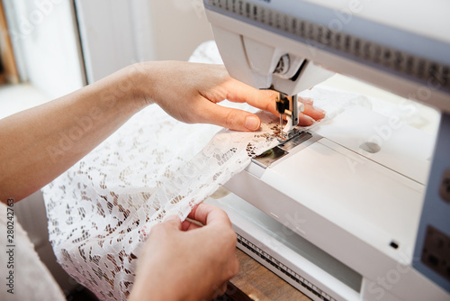 detail of a wedding dress being sewn 