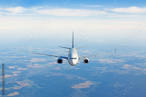 Passenger jet airplane flying in clear sky to destination.
